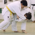 Judo passage ceinture jaune : projection Uki Goshi sur tatami